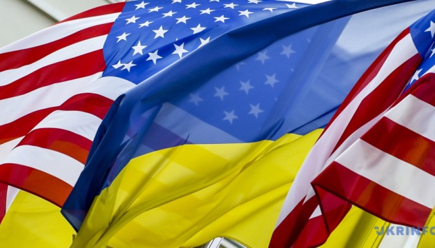 Flags of the USA and Ukraine waving together, symbolizing international relations and cooperation.